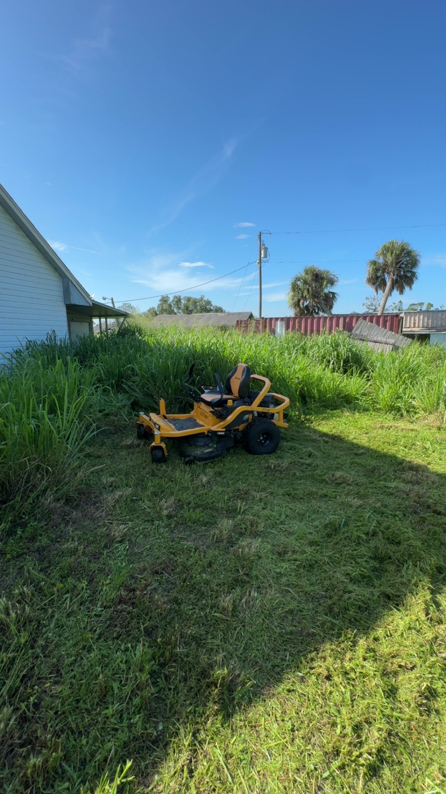 Lot clearing and overgrowth removal in North Port FL — zero-turn mower on overgrown yard